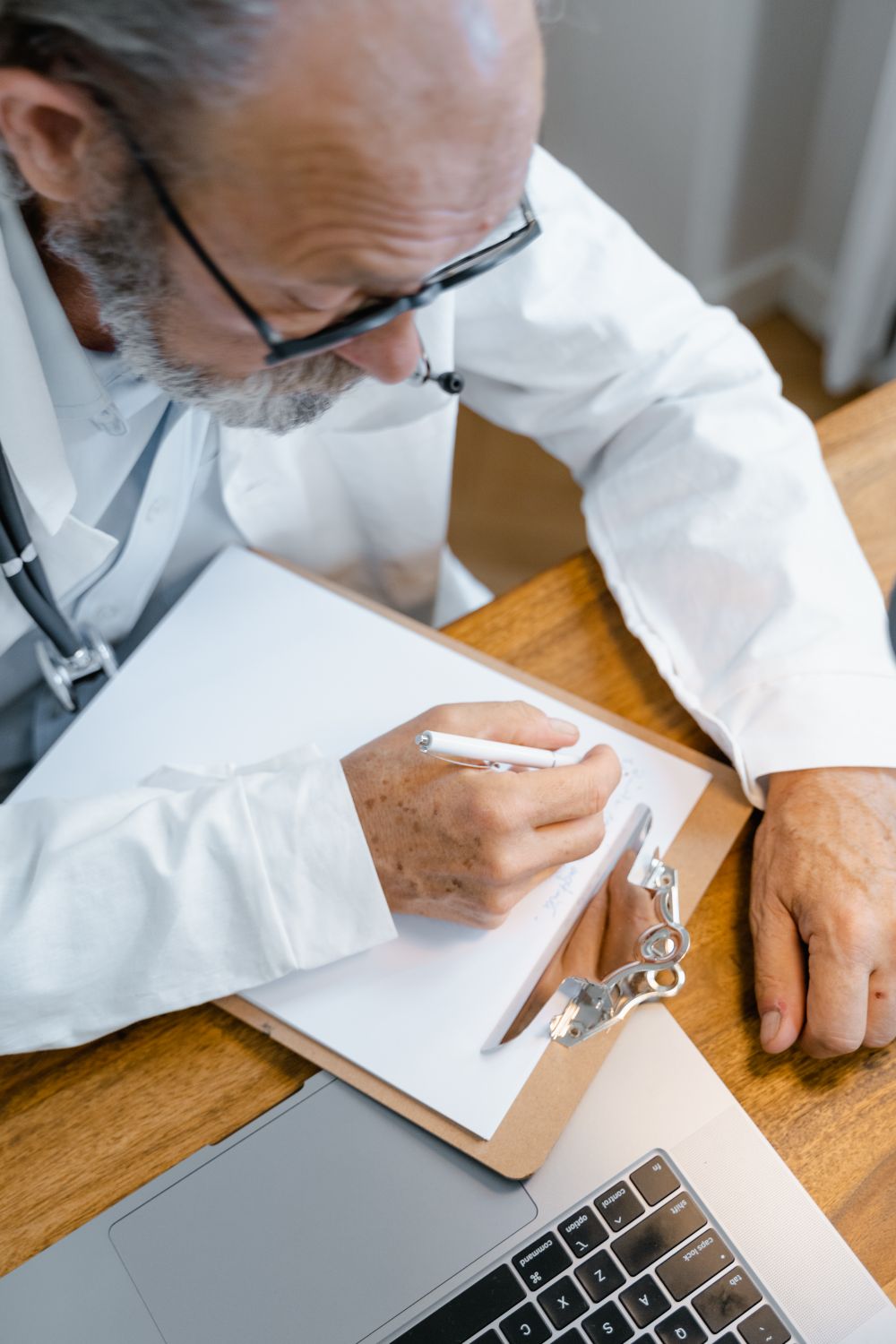 A doctor writing notes on a clipboard